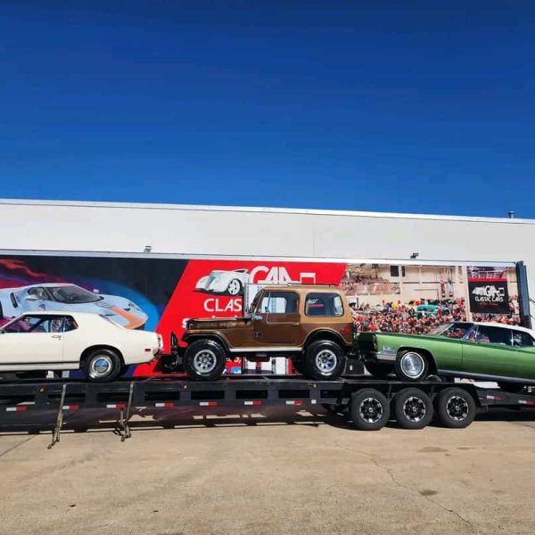 Auto transport trailer carrying vintage cars for shipping.